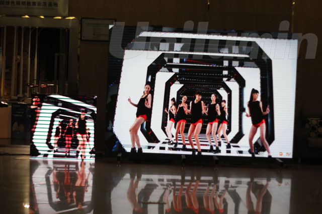 图为：专业摄像机6400秒快门拍摄画面仍旧保真，右边大屏幕为东升国际官网LED UTV高清幼间距产品